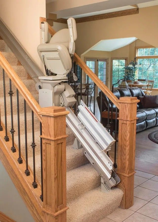 A stair lift is sitting on top of a set of stairs in a living room.