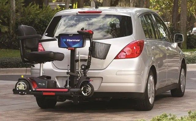 A mobility scooter is attached to the back of a car.