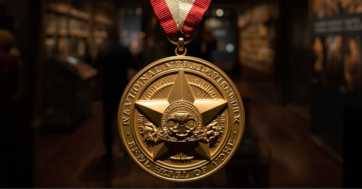 A golden commemorative Medal of Honor coin or medallion suspended by a red and white ribbon in a dimly lit museum hallway with historical exhibits in the background.