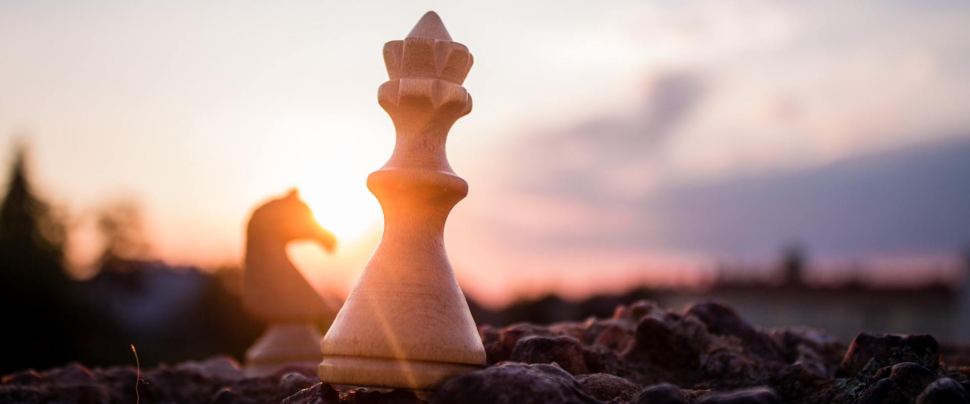 Chess pieces on rocky ground