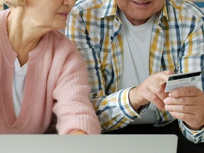 Two elderly people talking about a credit card.