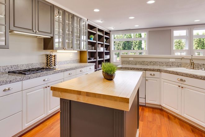 a kitchen with white cabinets and a stainless steel hood