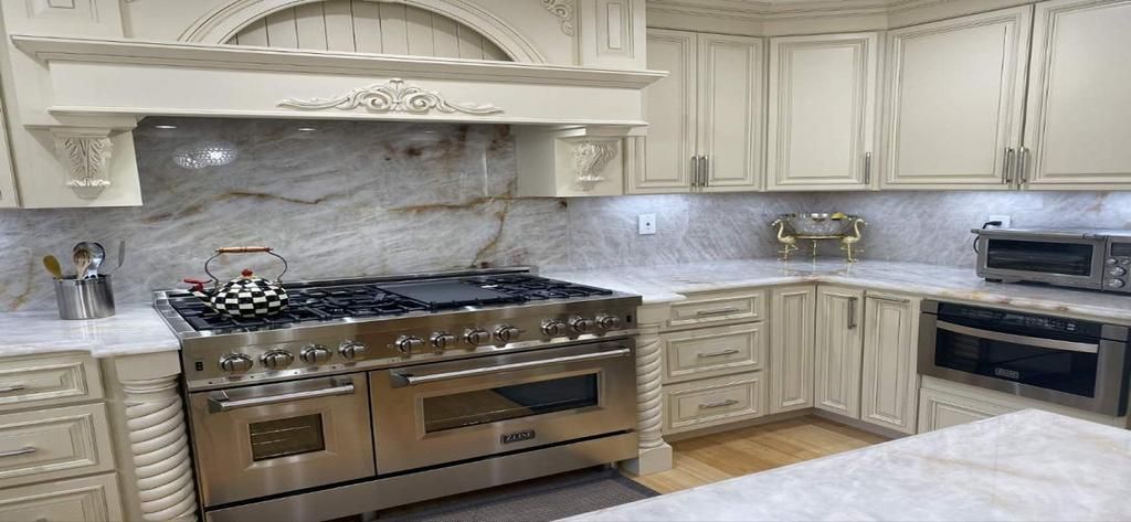 A kitchen with stainless steel appliances and white cabinets.