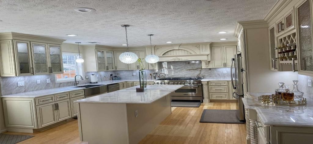 A large kitchen with white cabinets and stainless steel appliances.
