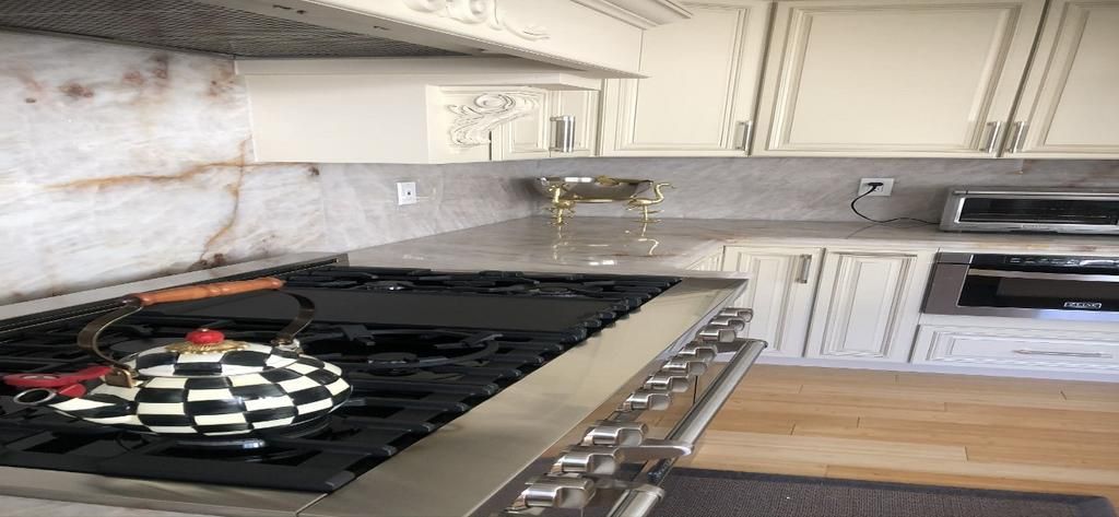 A kitchen with a stove top oven and a tea kettle on it.