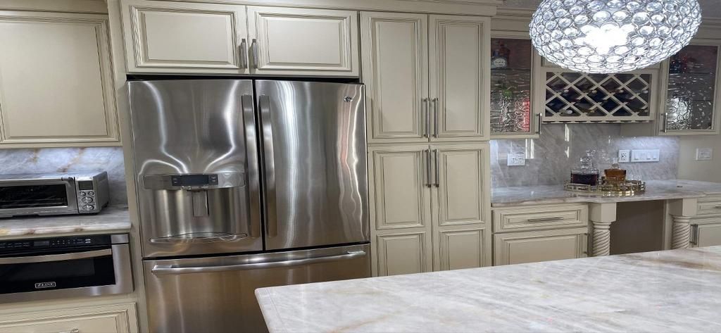 A kitchen with stainless steel appliances and white cabinets.