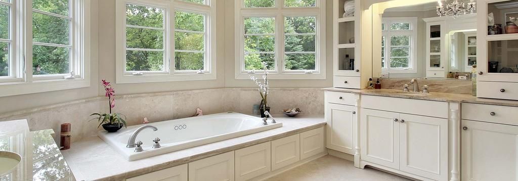 A bathroom with a tub , sink , and mirror.