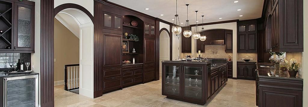 A kitchen with dark wood cabinets and a large island.