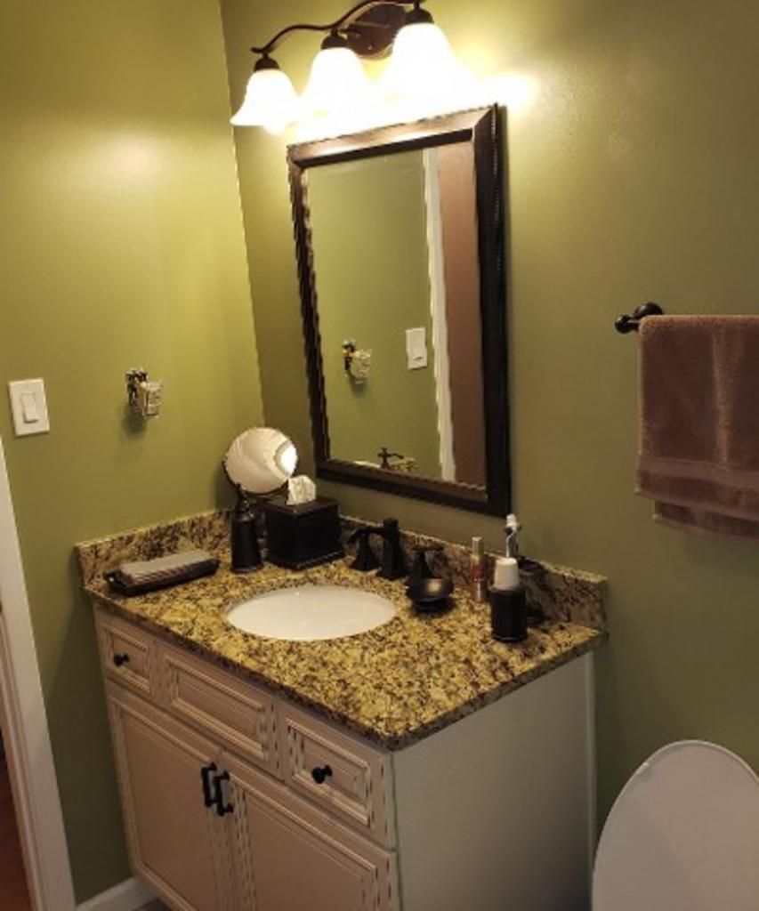 A bathroom with a sink , mirror and toilet.