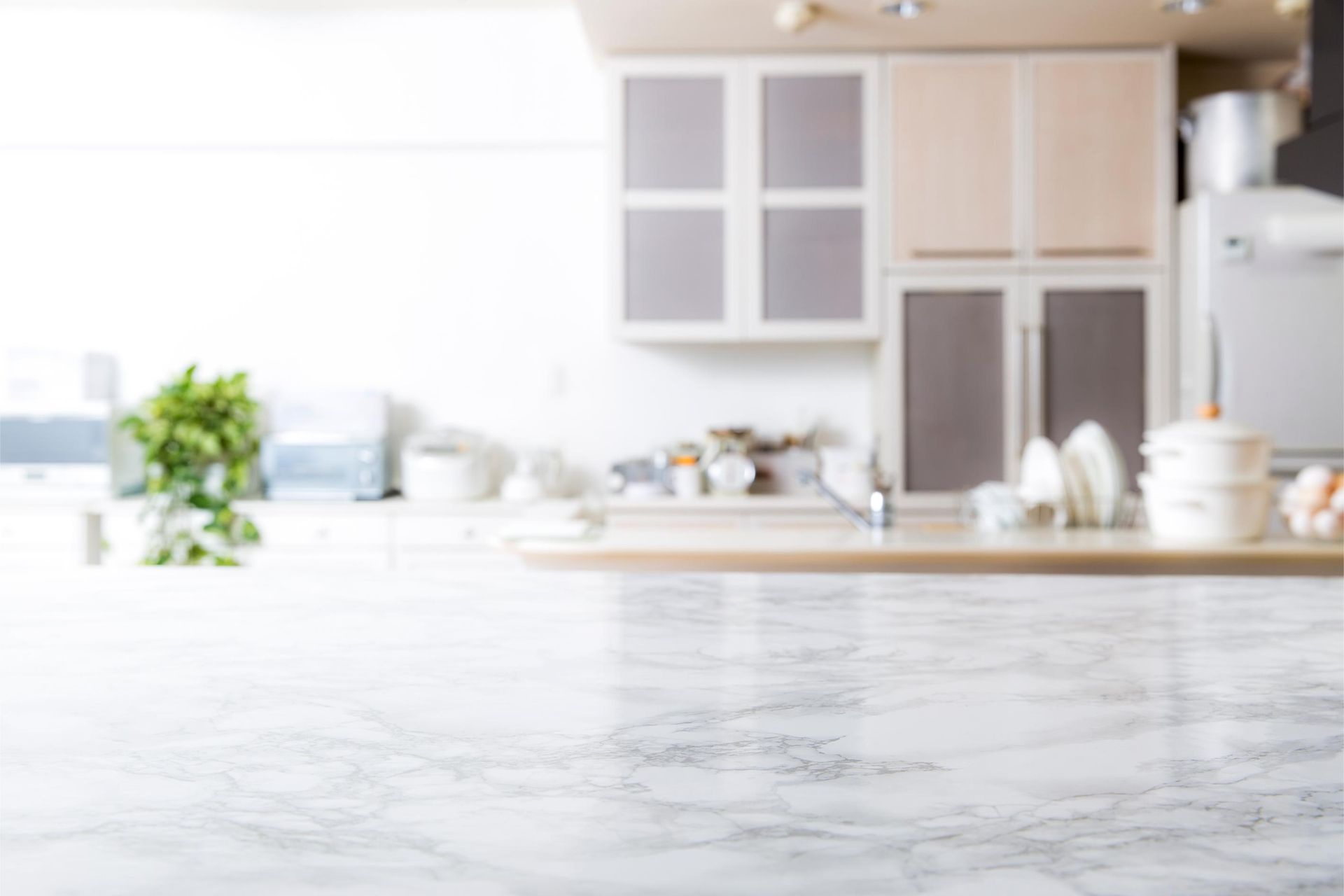 A blurred image of a kitchen with a marble counter top.