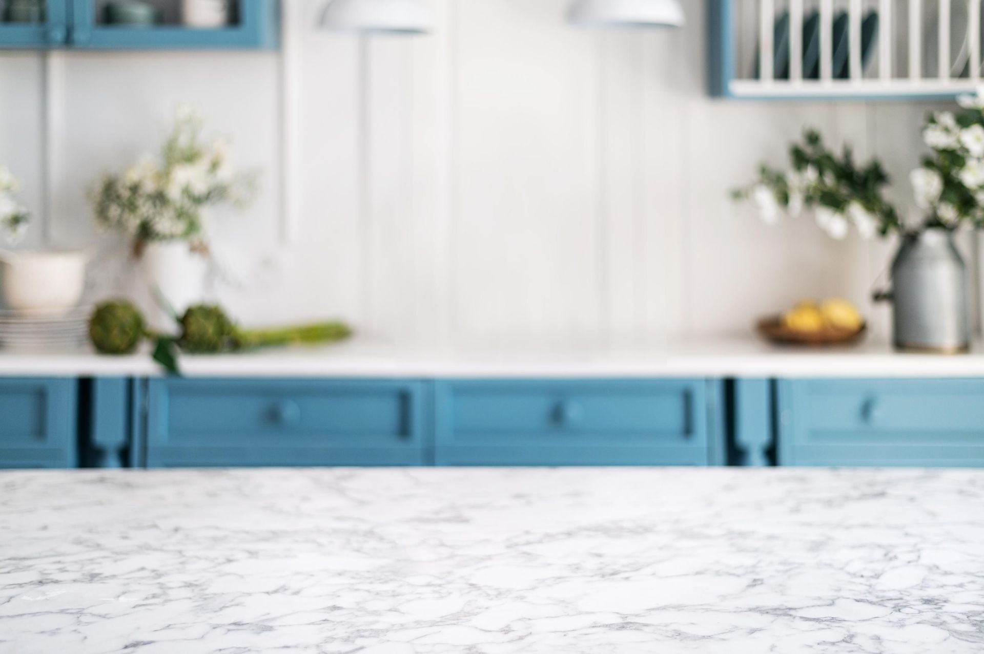 A kitchen with blue cabinets and a white counter top.