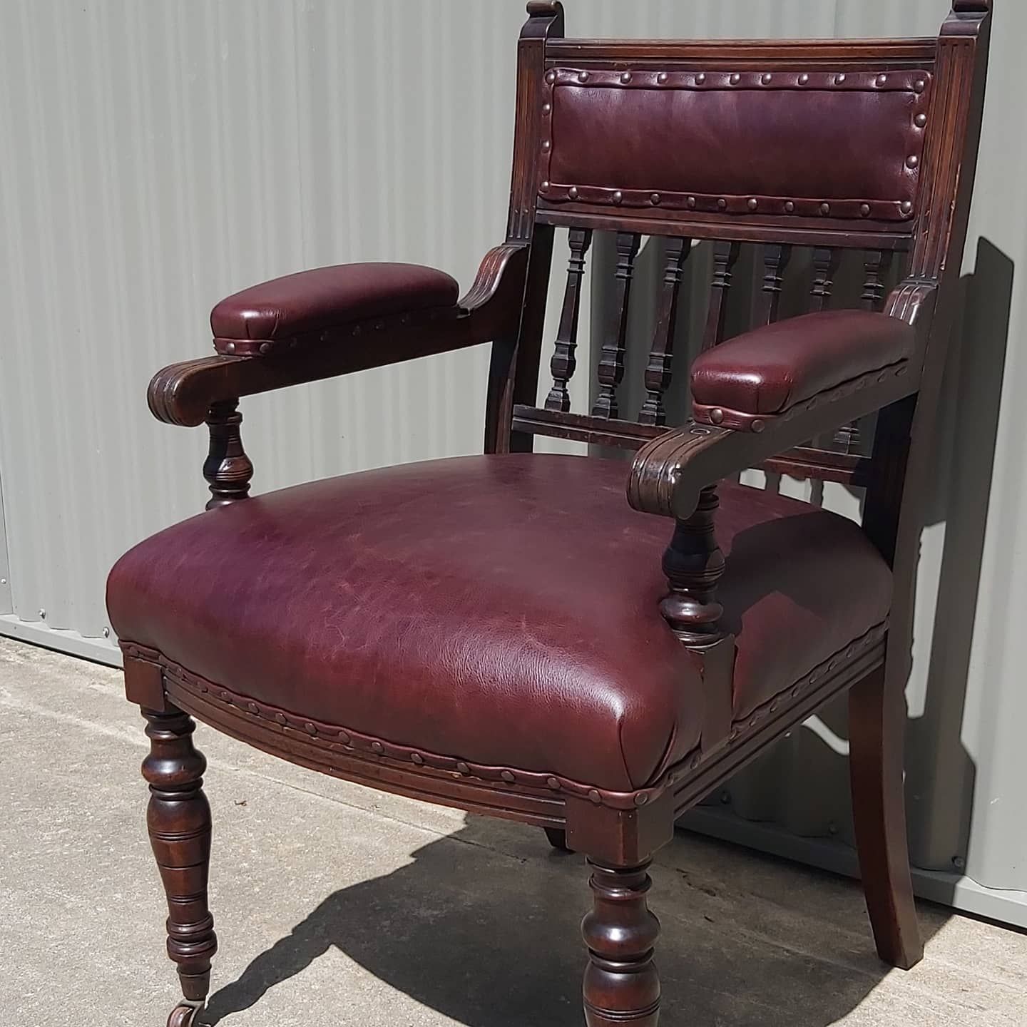 A Brown Leather Antique Armchair With Ornate Details and Burgundy Cushions — Cupitt's Quality Upholstery in Byron Bay, NSW