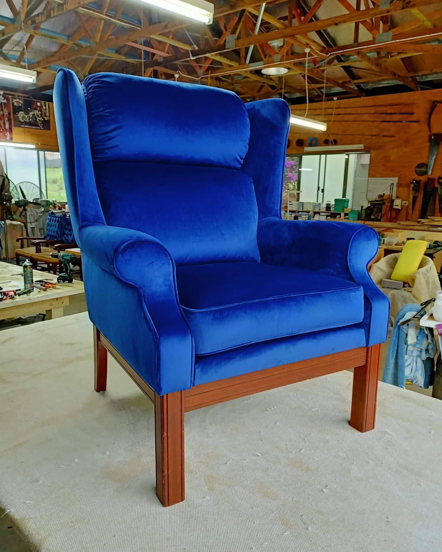 A Blue Velvet Wingback Chair With Wooden Legs — Cupitt's Quality Upholstery in Yamba, NSW