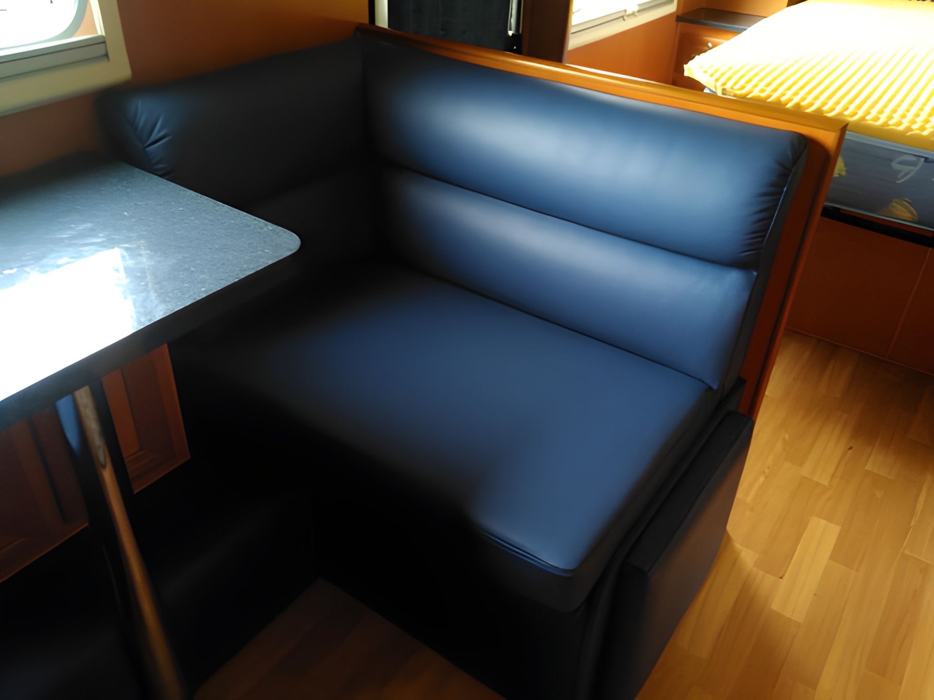A Dark Blue Booth Seating in a Caravan With a Table Attached — Cupitt's Quality Upholstery in Rous, NSW