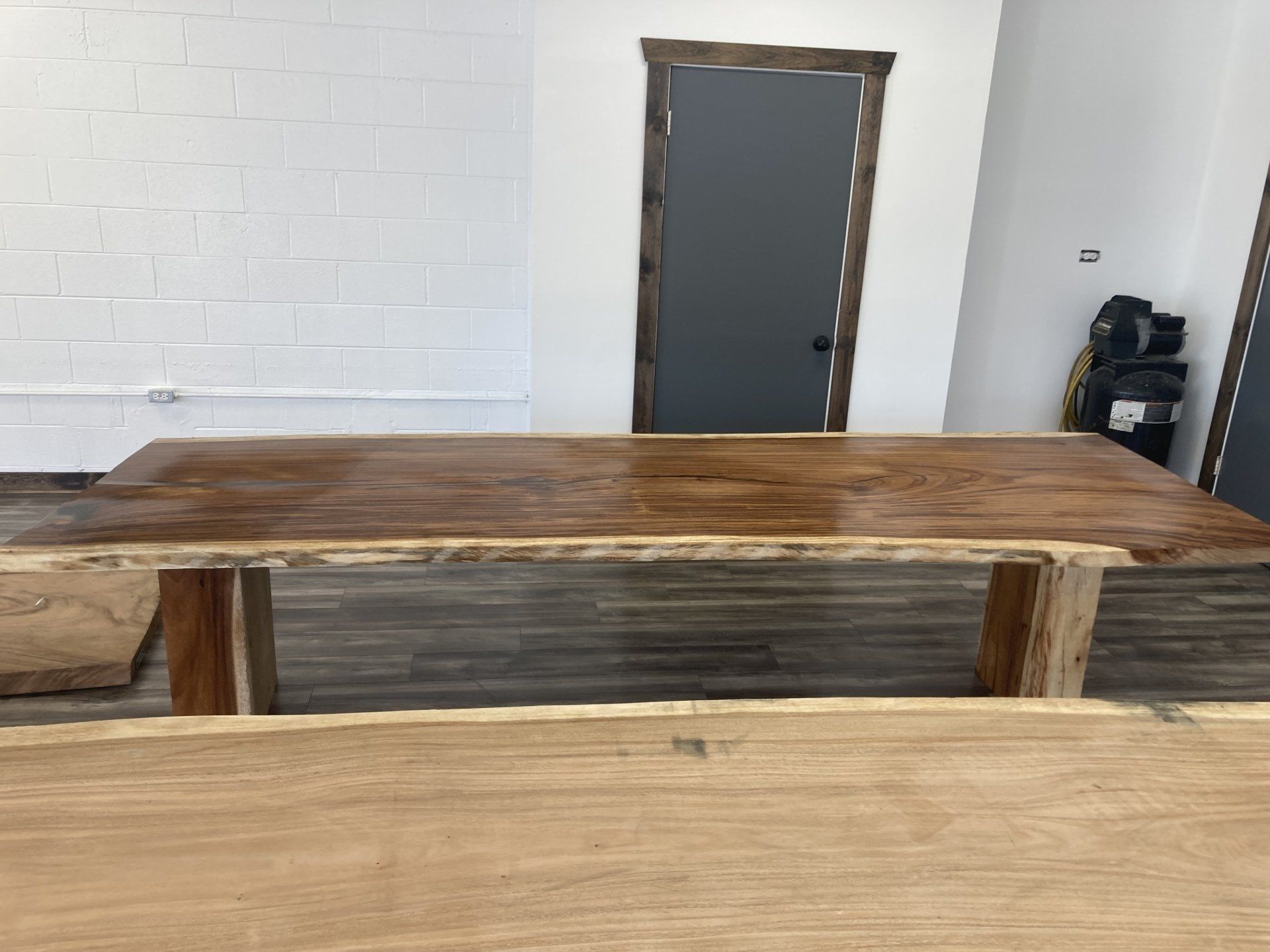 A wooden table is sitting in a room next to a door.