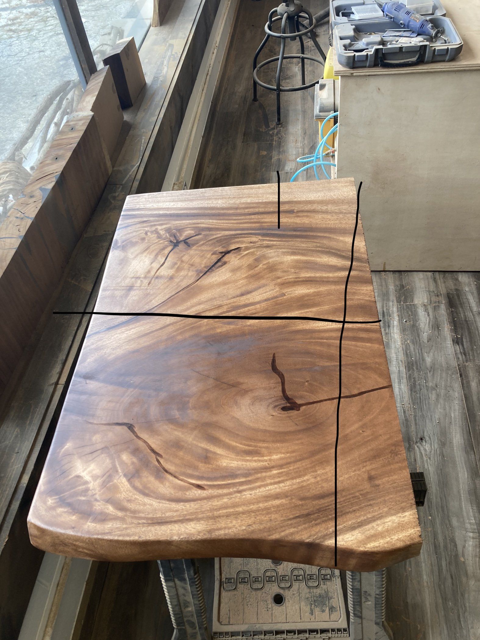 A piece of wood is sitting on top of a table next to a window.
