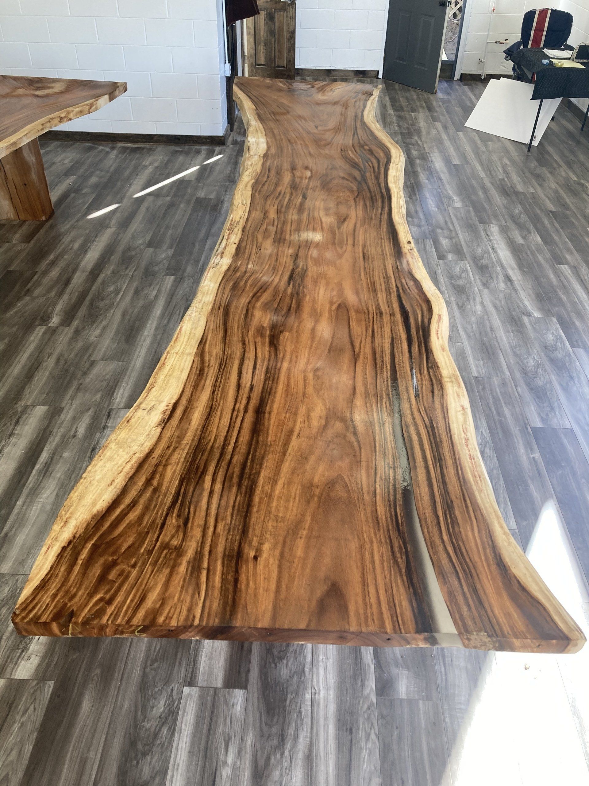 A large piece of wood is sitting on a wooden floor in a room.