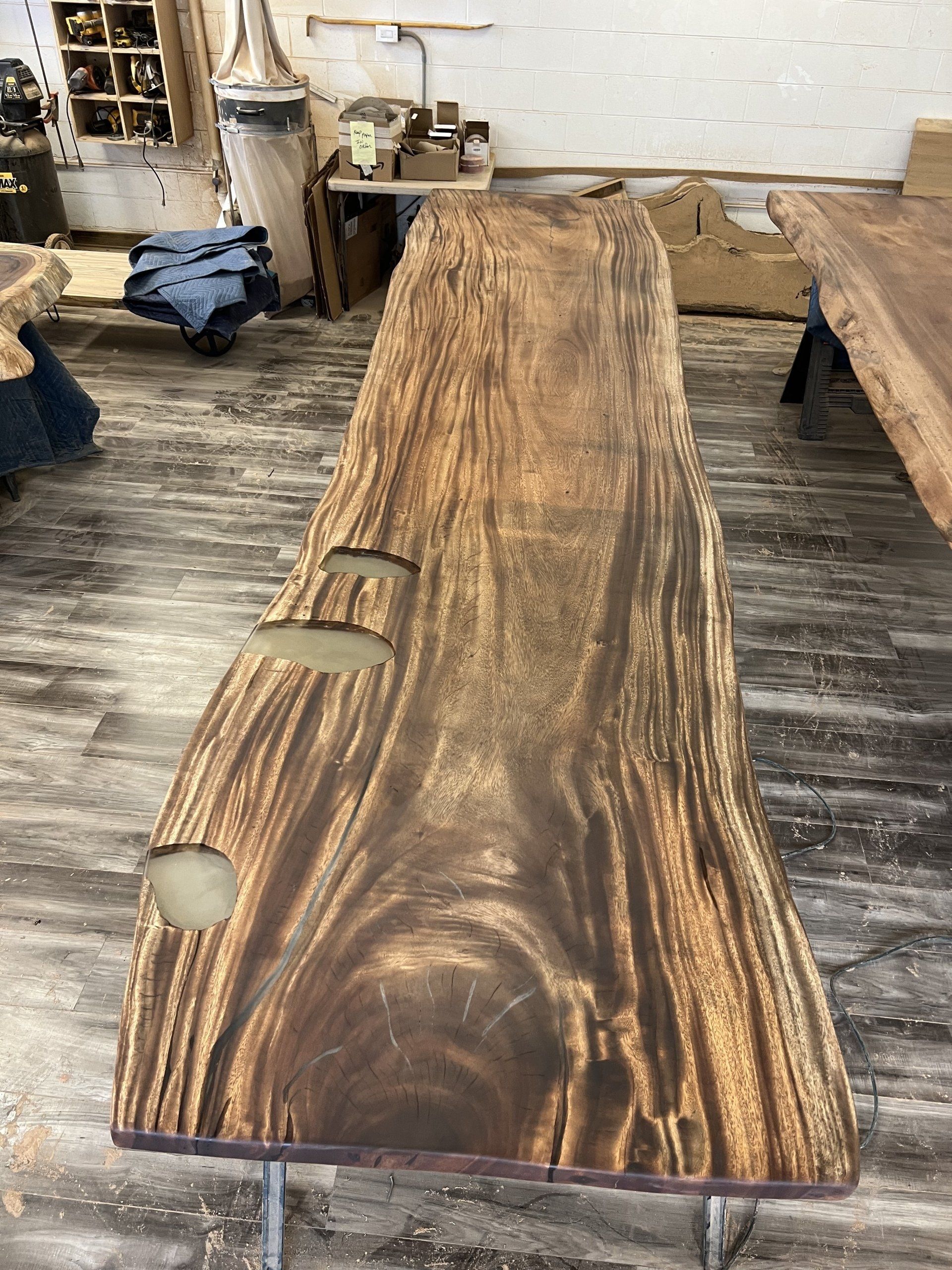 A long piece of wood is sitting on a wooden floor in a room.