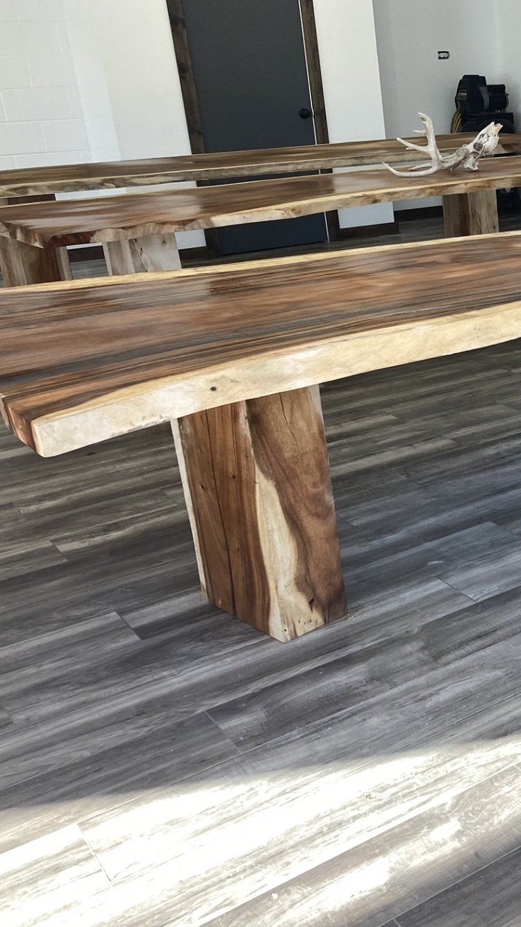 A wooden bench is sitting on a wooden floor in a room.