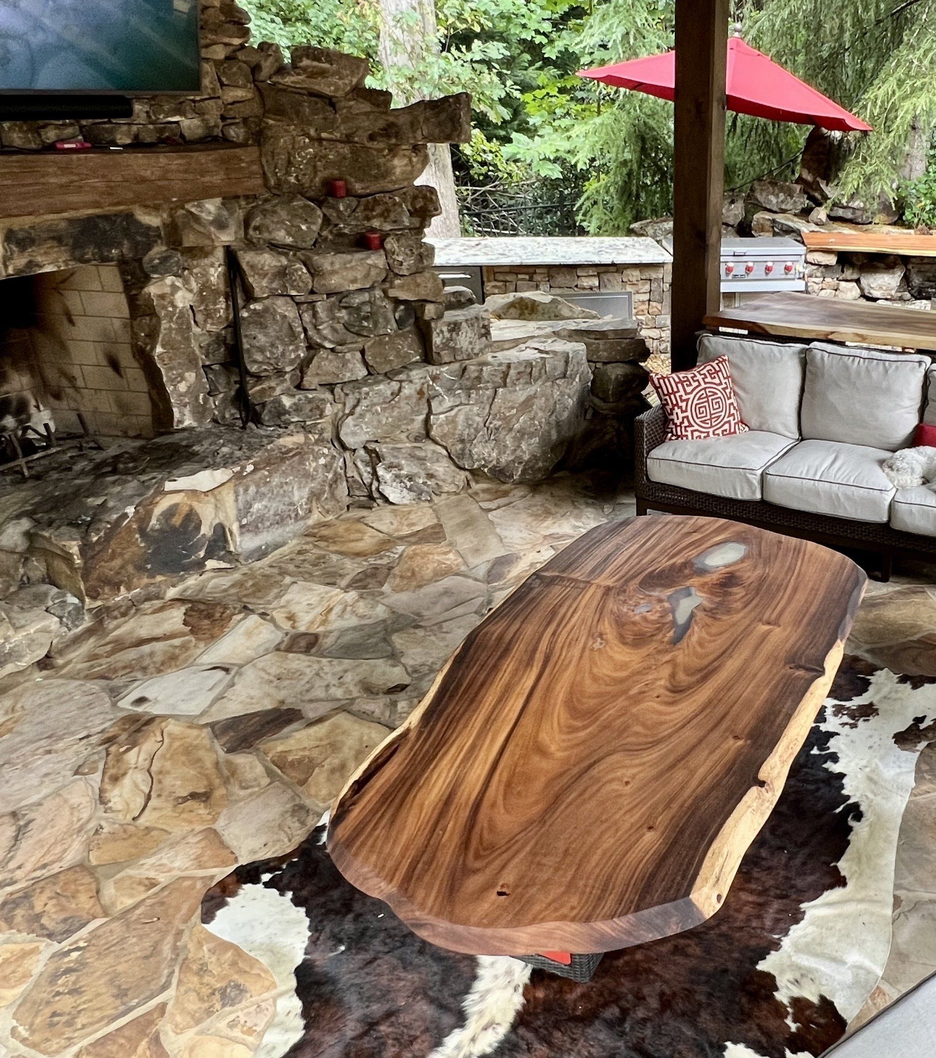 A living room with a cowhide rug and a wooden table