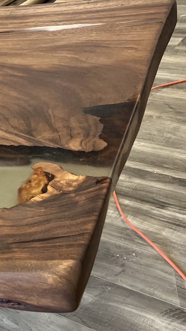 A close up of a wooden table with resin on it.