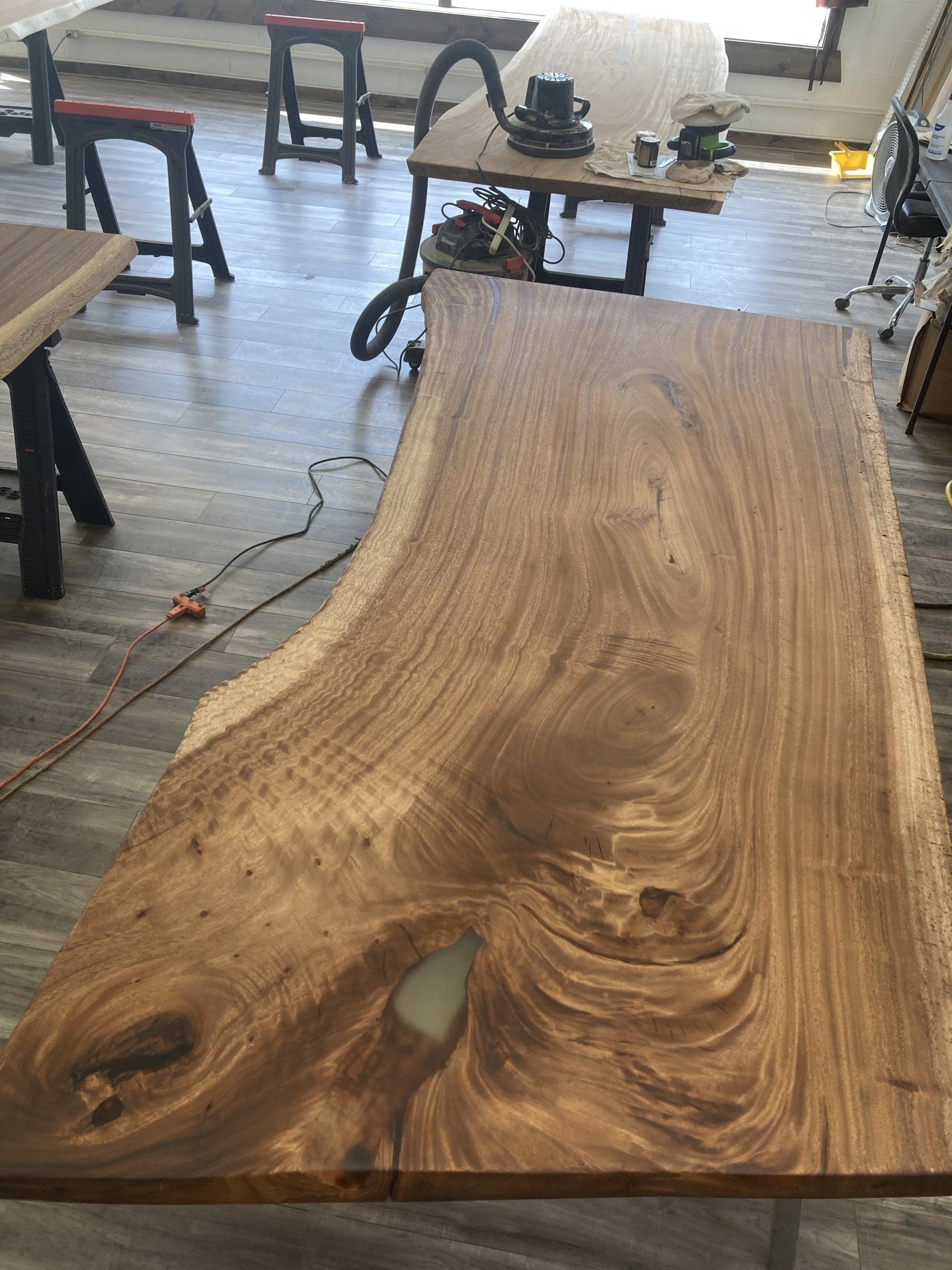 A large piece of wood is sitting on top of a wooden table in a room.