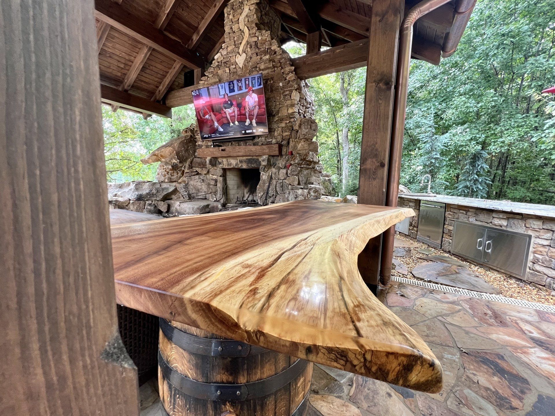 A wooden table with a tv on top of it in a patio area.