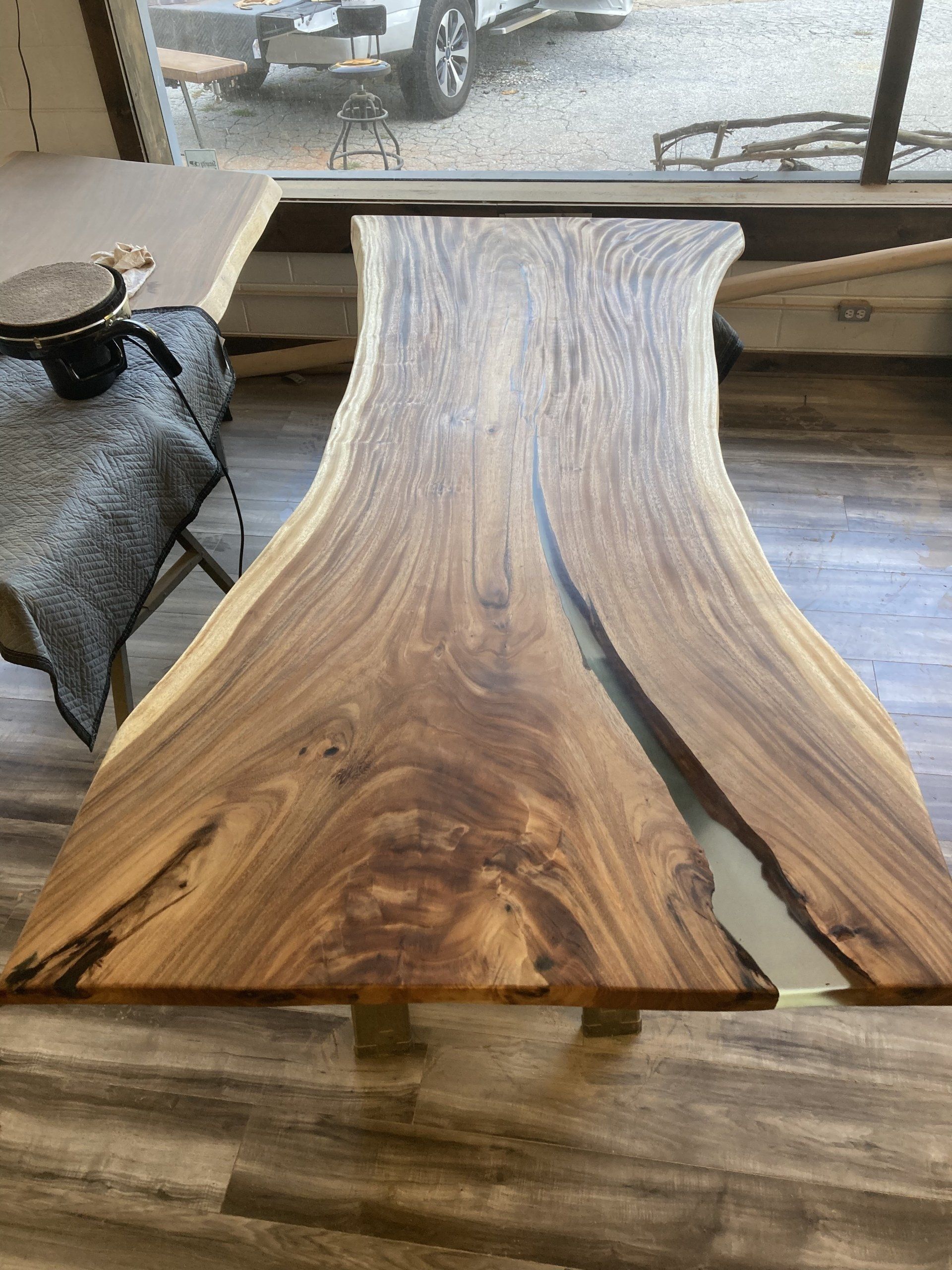 A wooden table is sitting on a wooden floor in front of a window.
