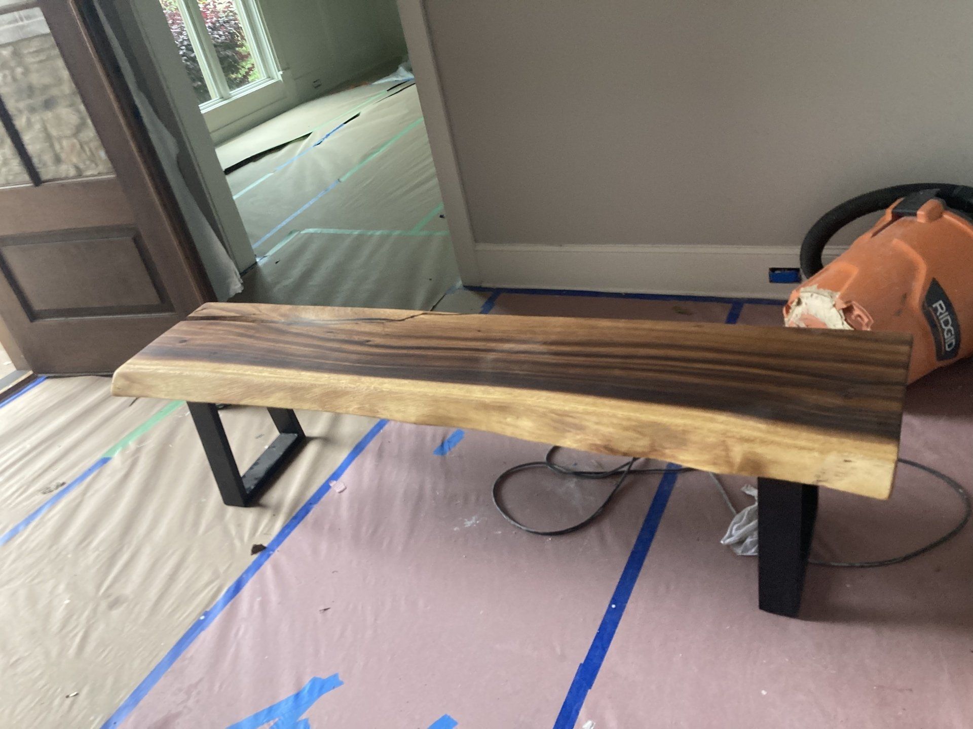 A wooden bench is sitting on the floor in a room.