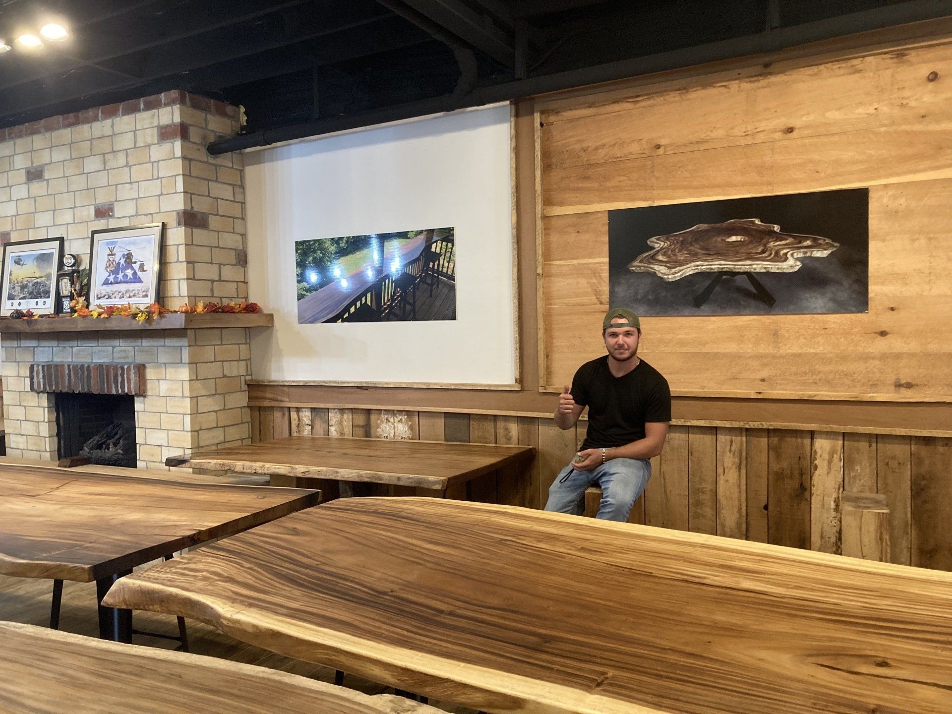 A man is sitting on a wooden table in a room.