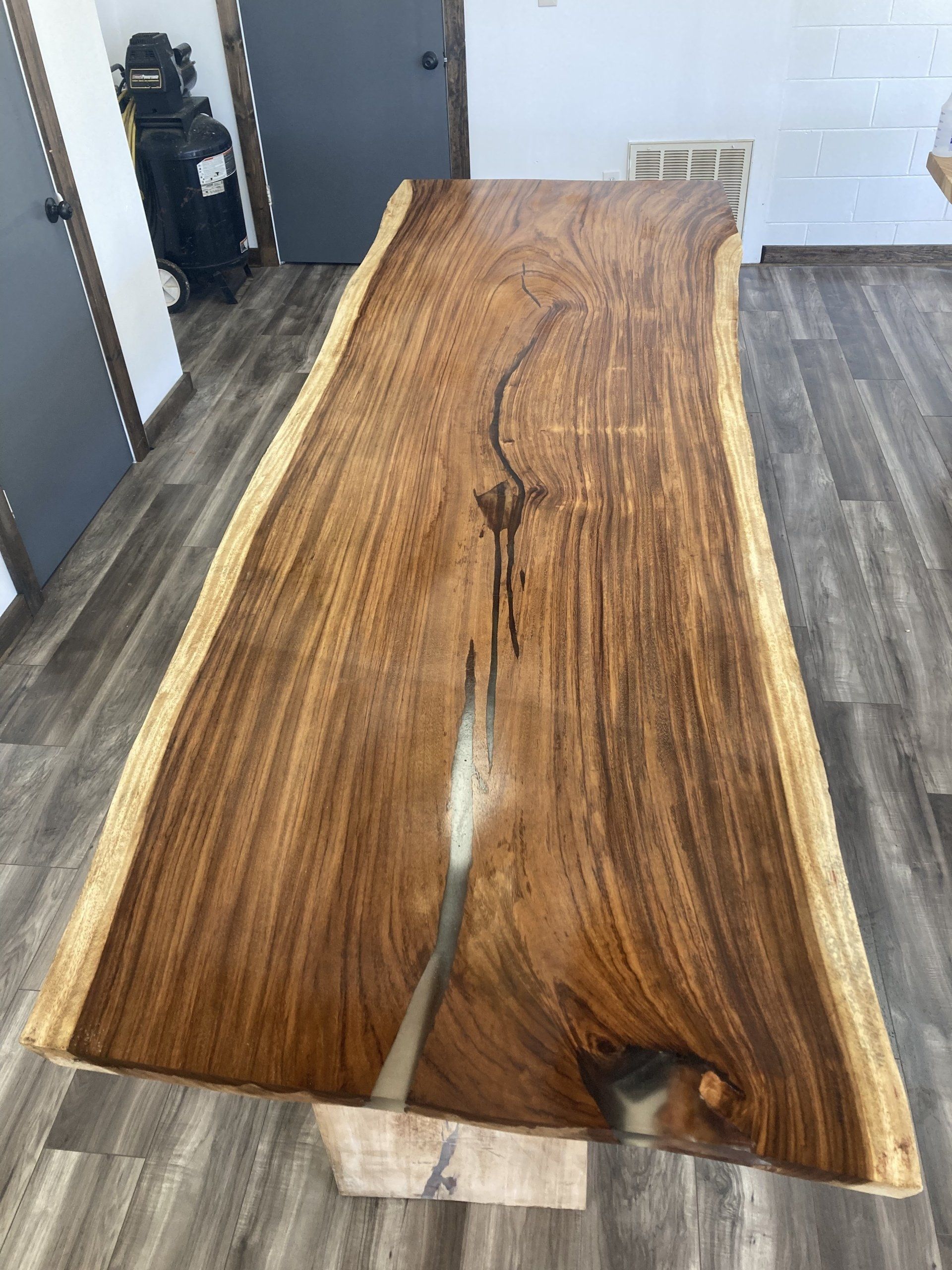 A large piece of wood is sitting on a wooden floor in a room.