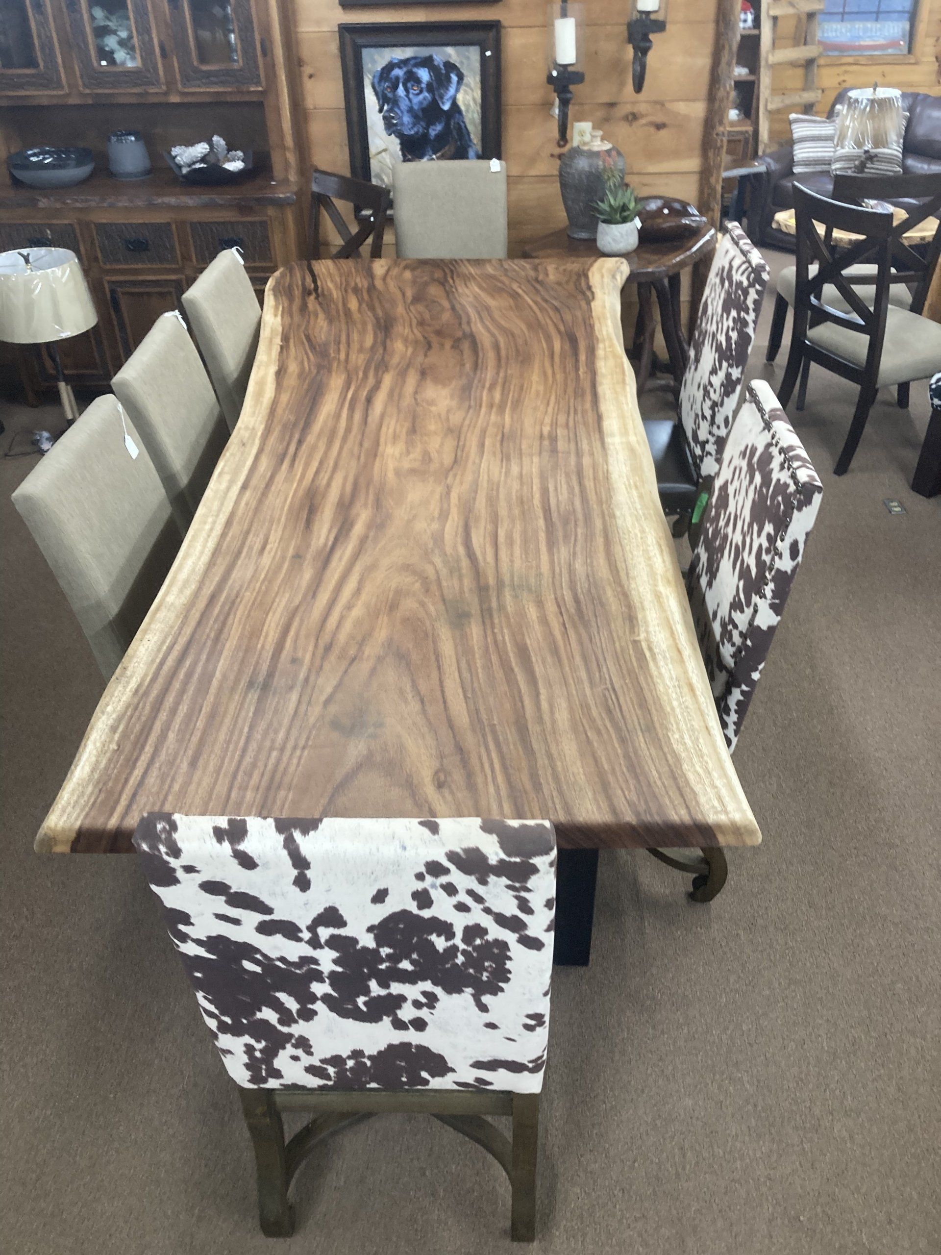 A wooden table with a cow print chair in front of it
