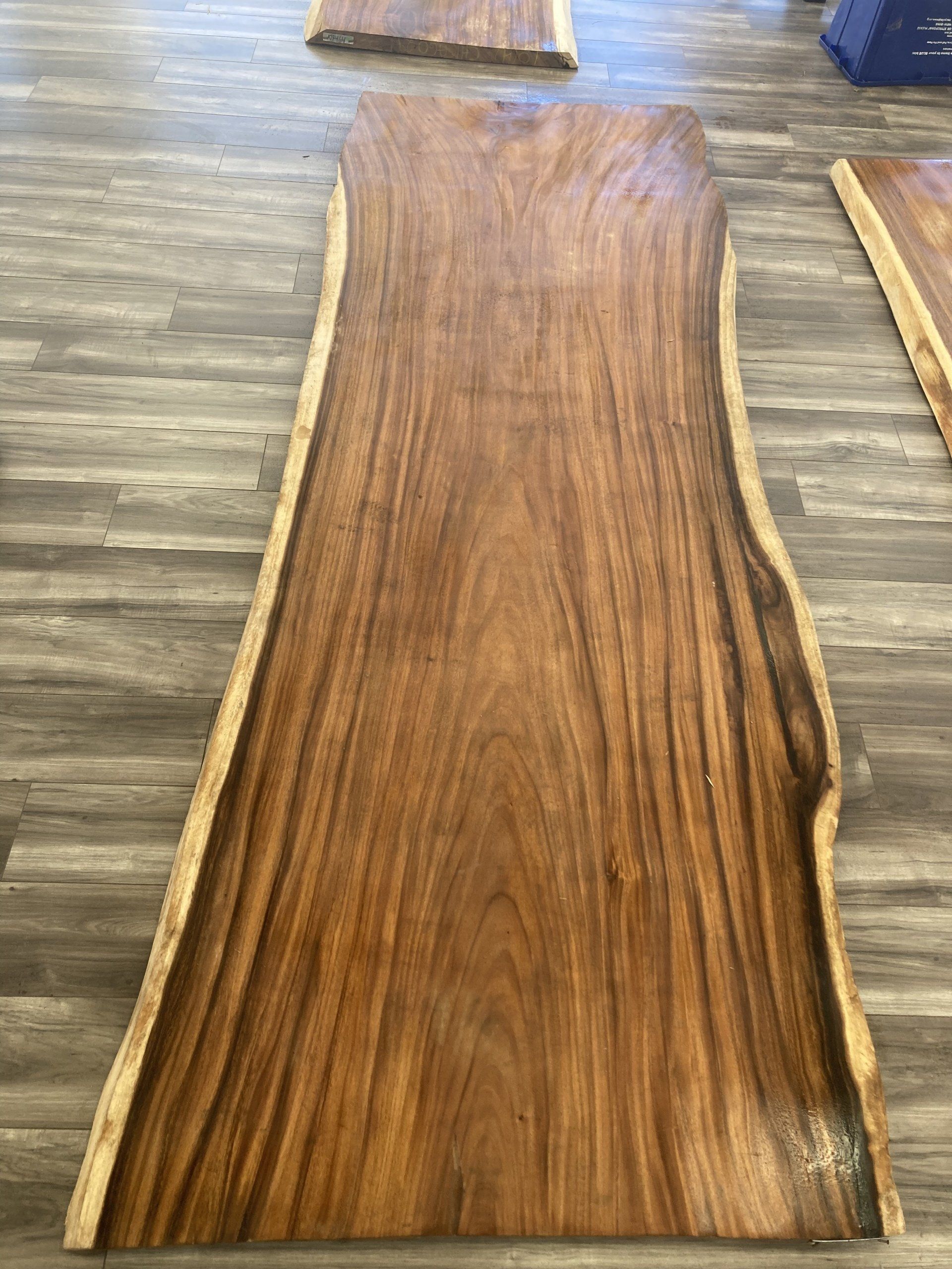 A large piece of wood is sitting on a wooden floor.