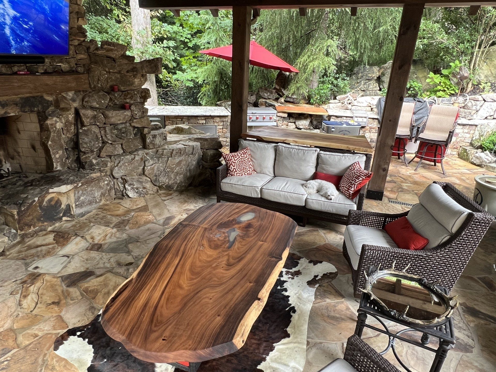 A living room with a couch , chairs , a table and a television.