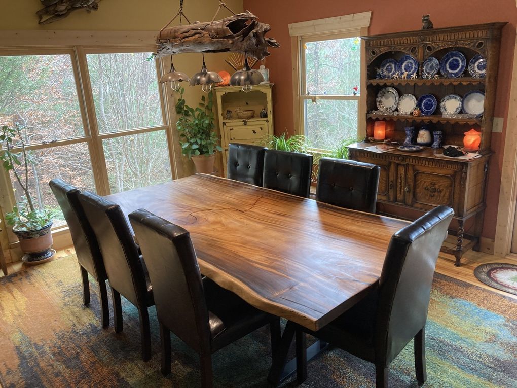 A dining room with a long wooden table and chairs.