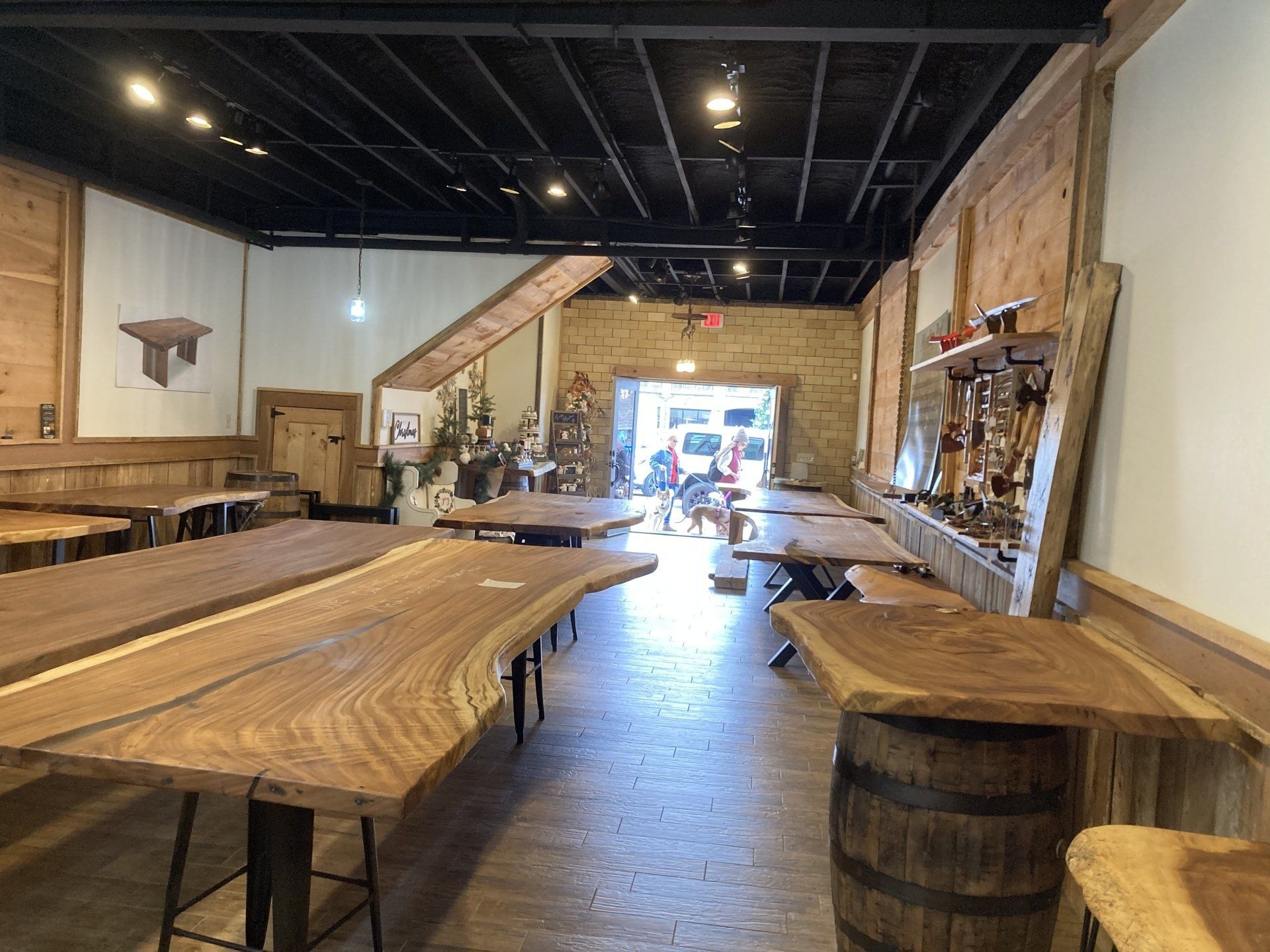 A large room filled with wooden tables and barrels.