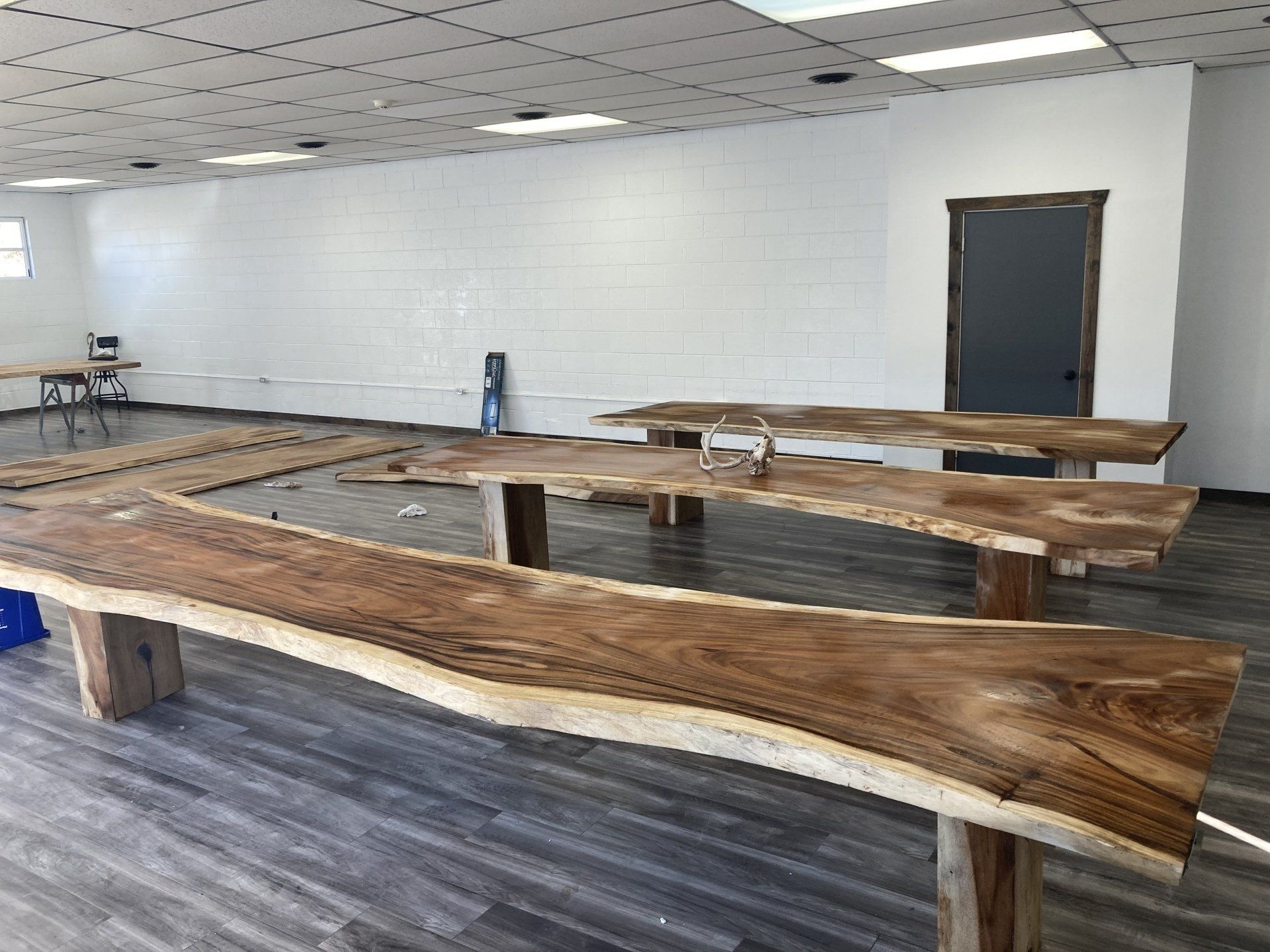 A room with a lot of wooden tables and benches.