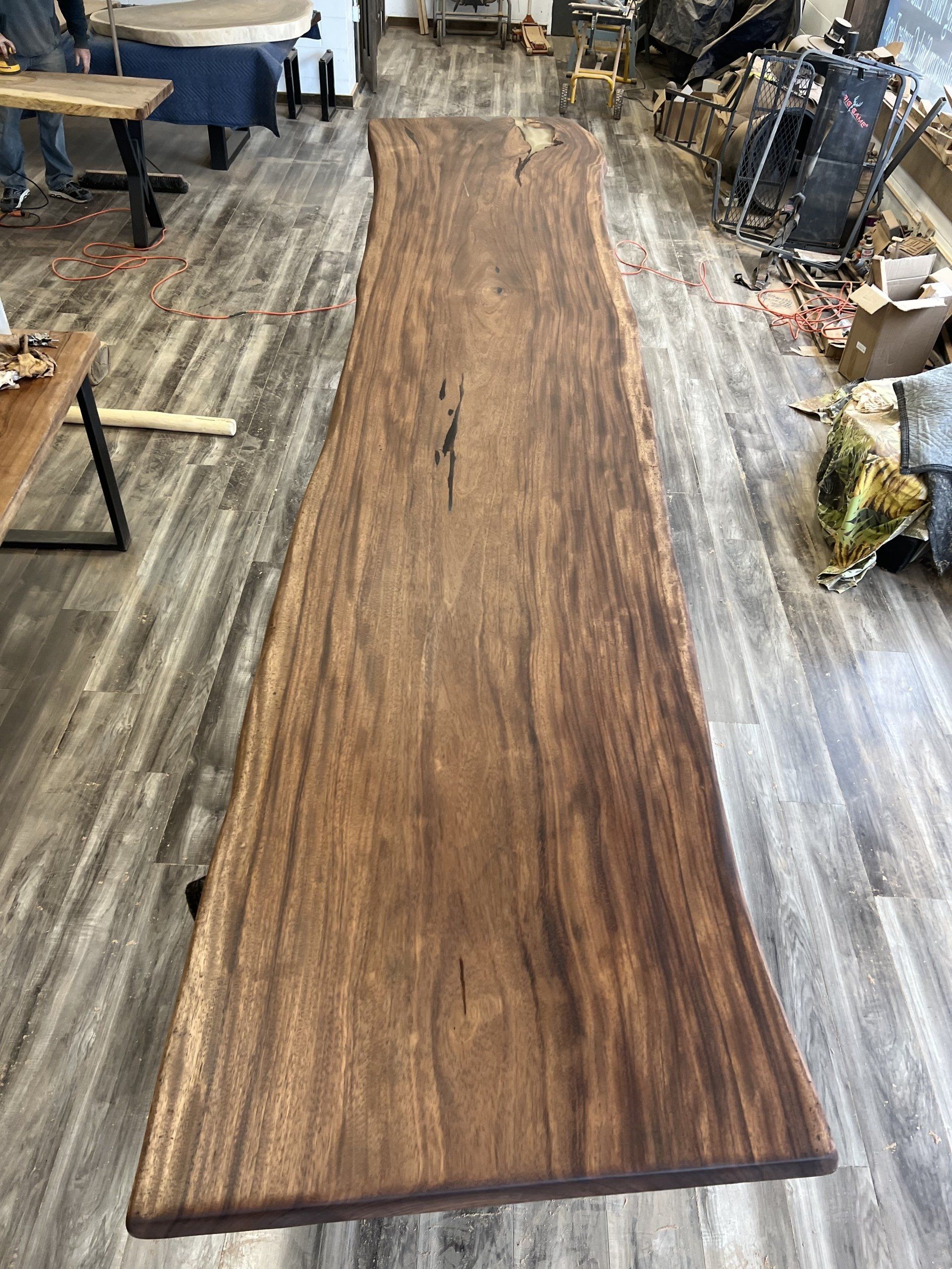 A long wooden table is sitting on a wooden floor in a room.