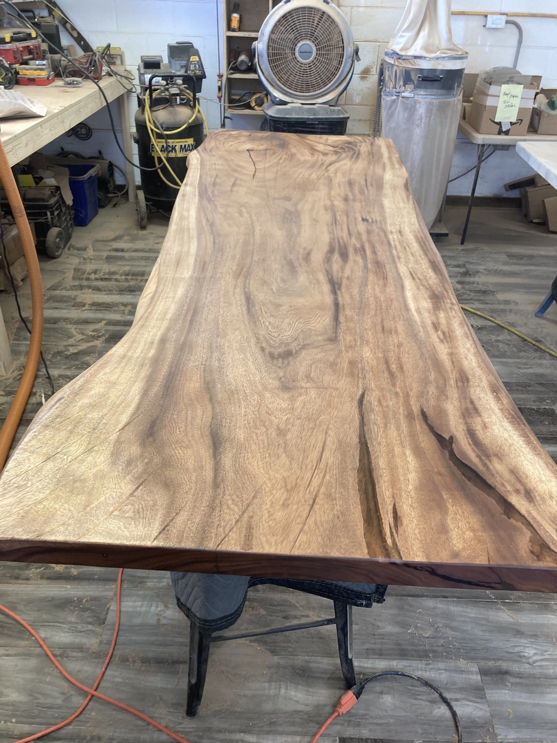 A large piece of wood is sitting on top of a wooden table.