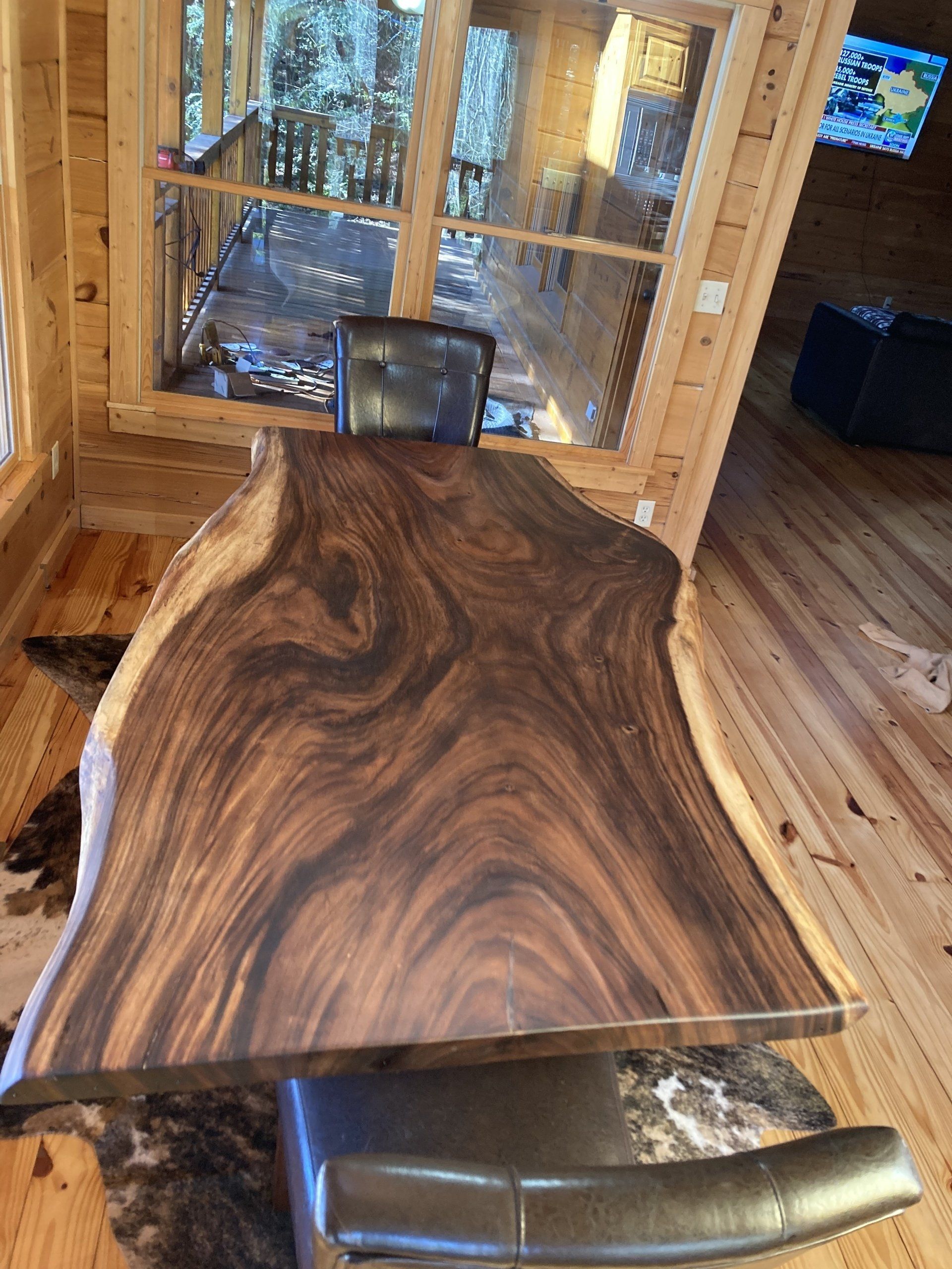 A large piece of wood is sitting on a wooden floor in a room.