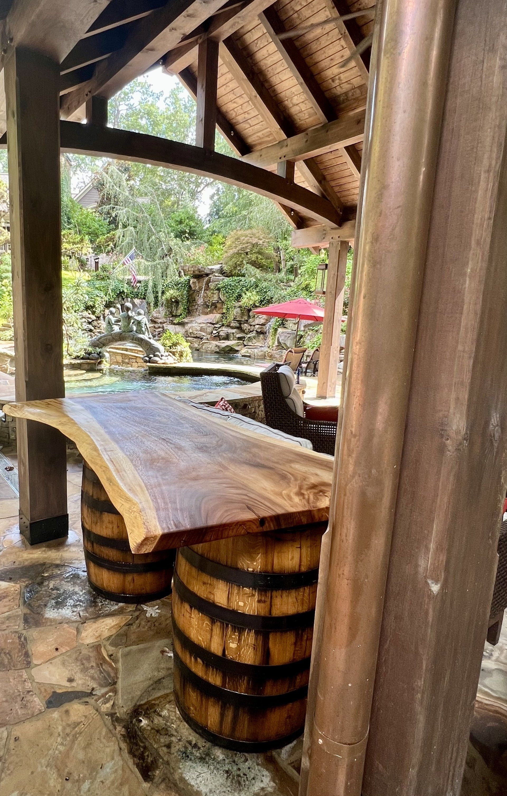 A wooden table with two wooden barrels underneath it.