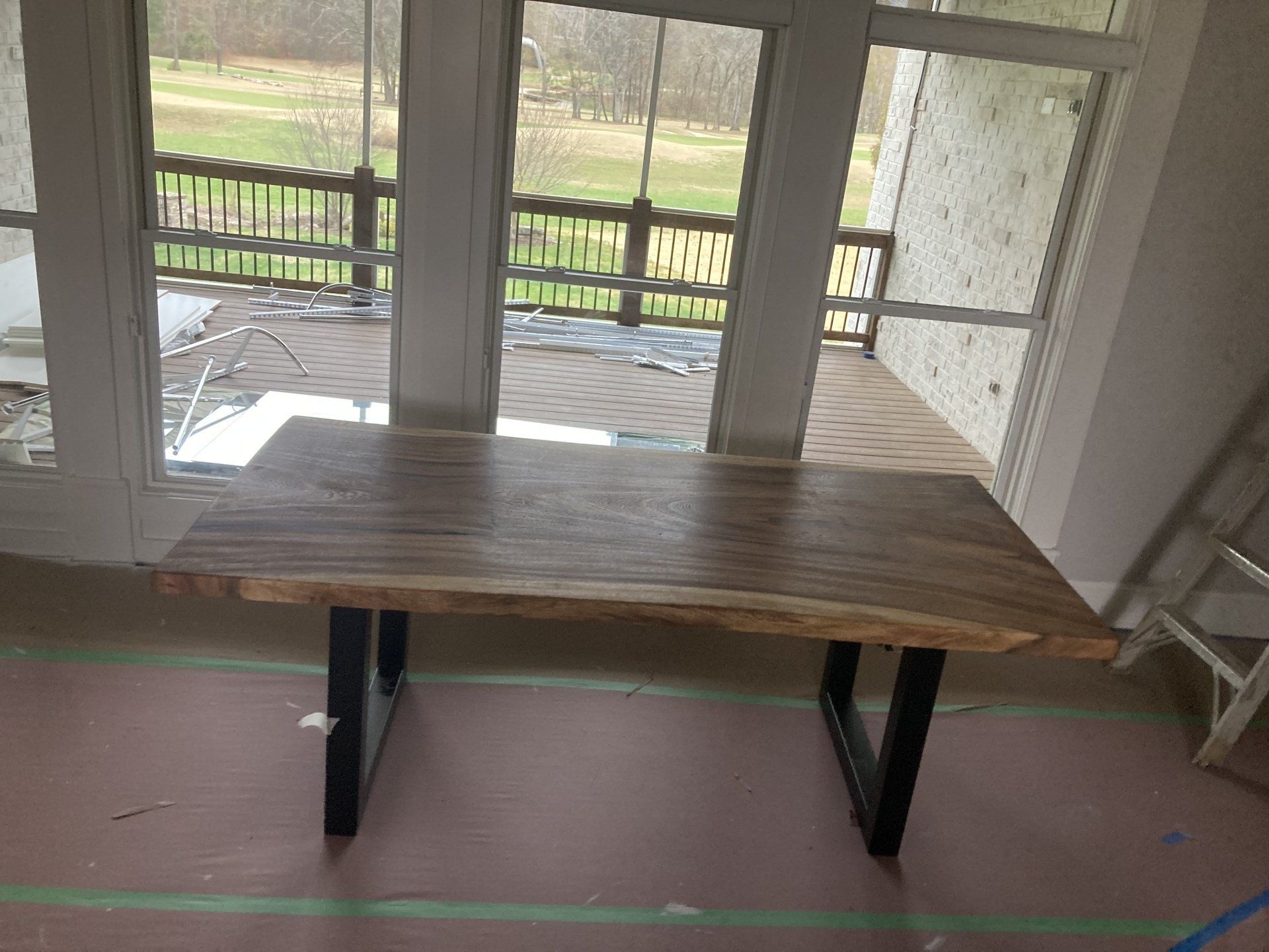 A wooden table in a room with a lot of windows