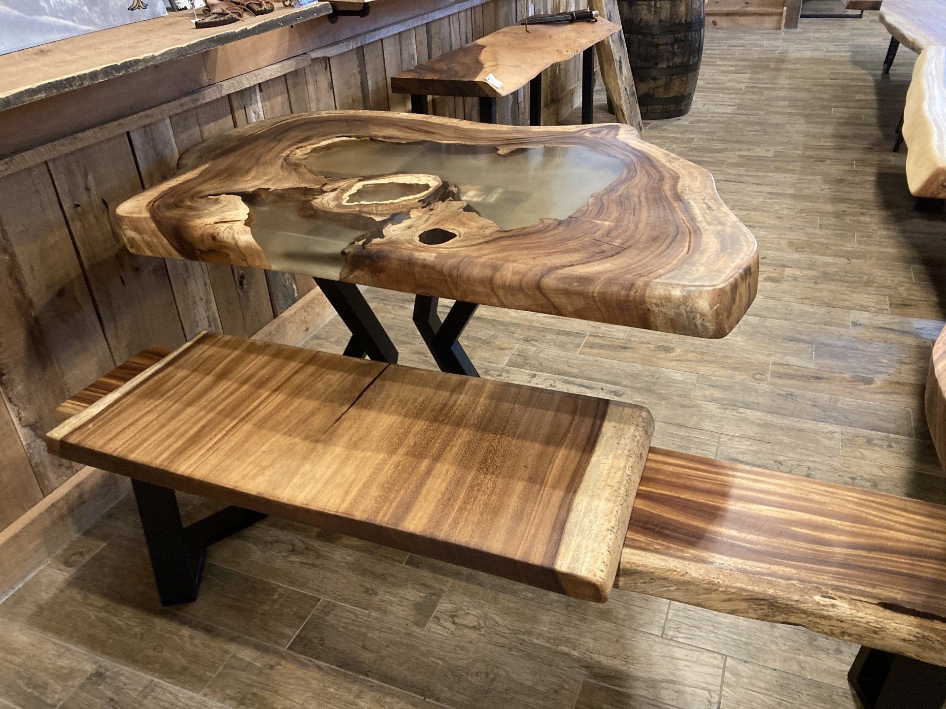 A wooden table with a bench underneath it in a room.