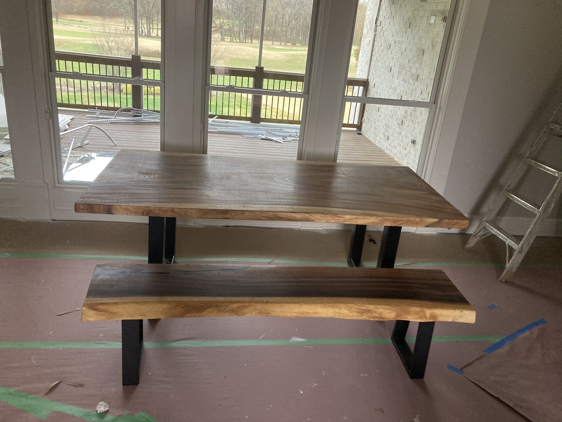 A wooden table with a bench in front of a window