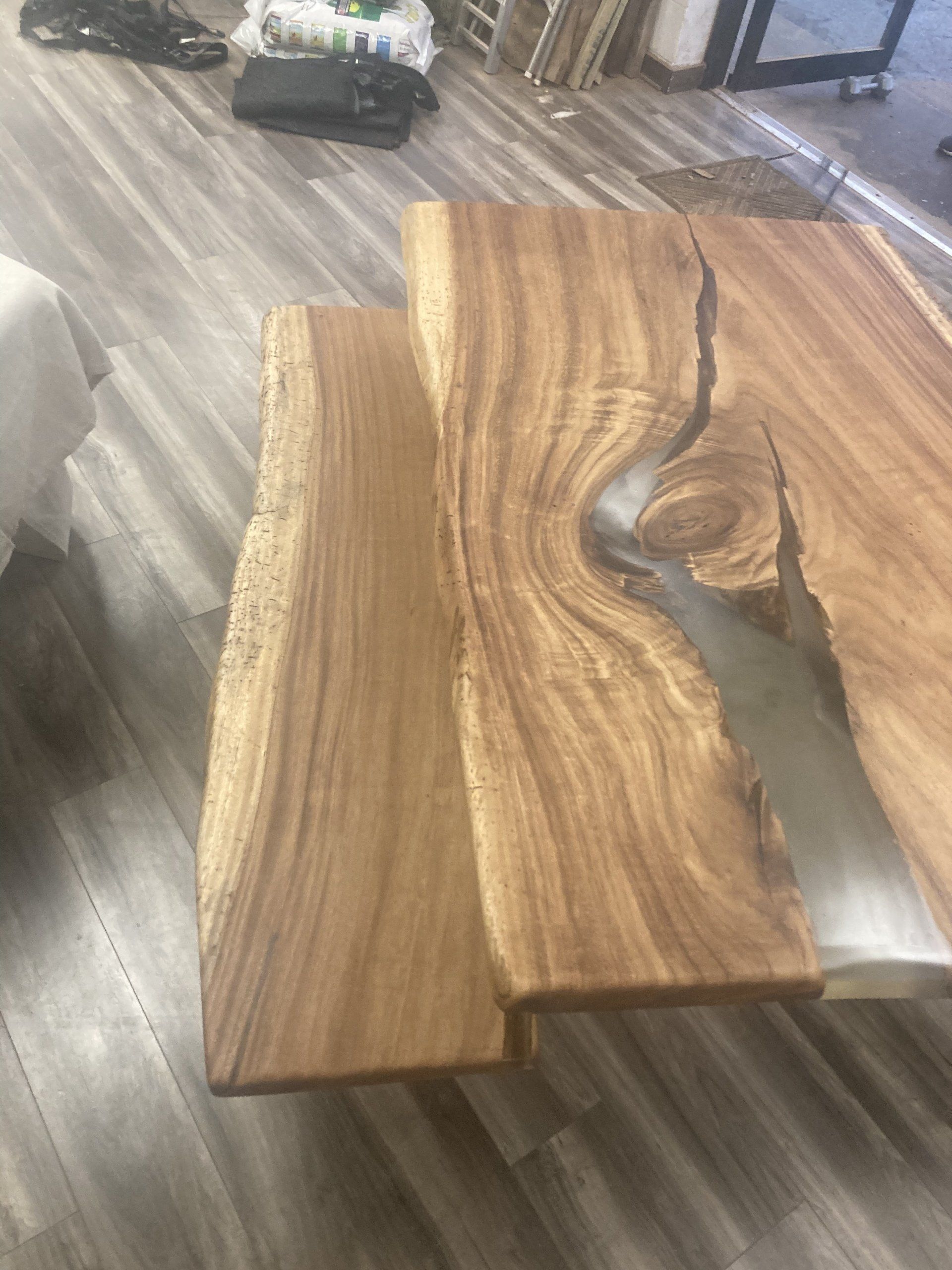 A wooden table with a river in the middle of it is sitting on a wooden floor.