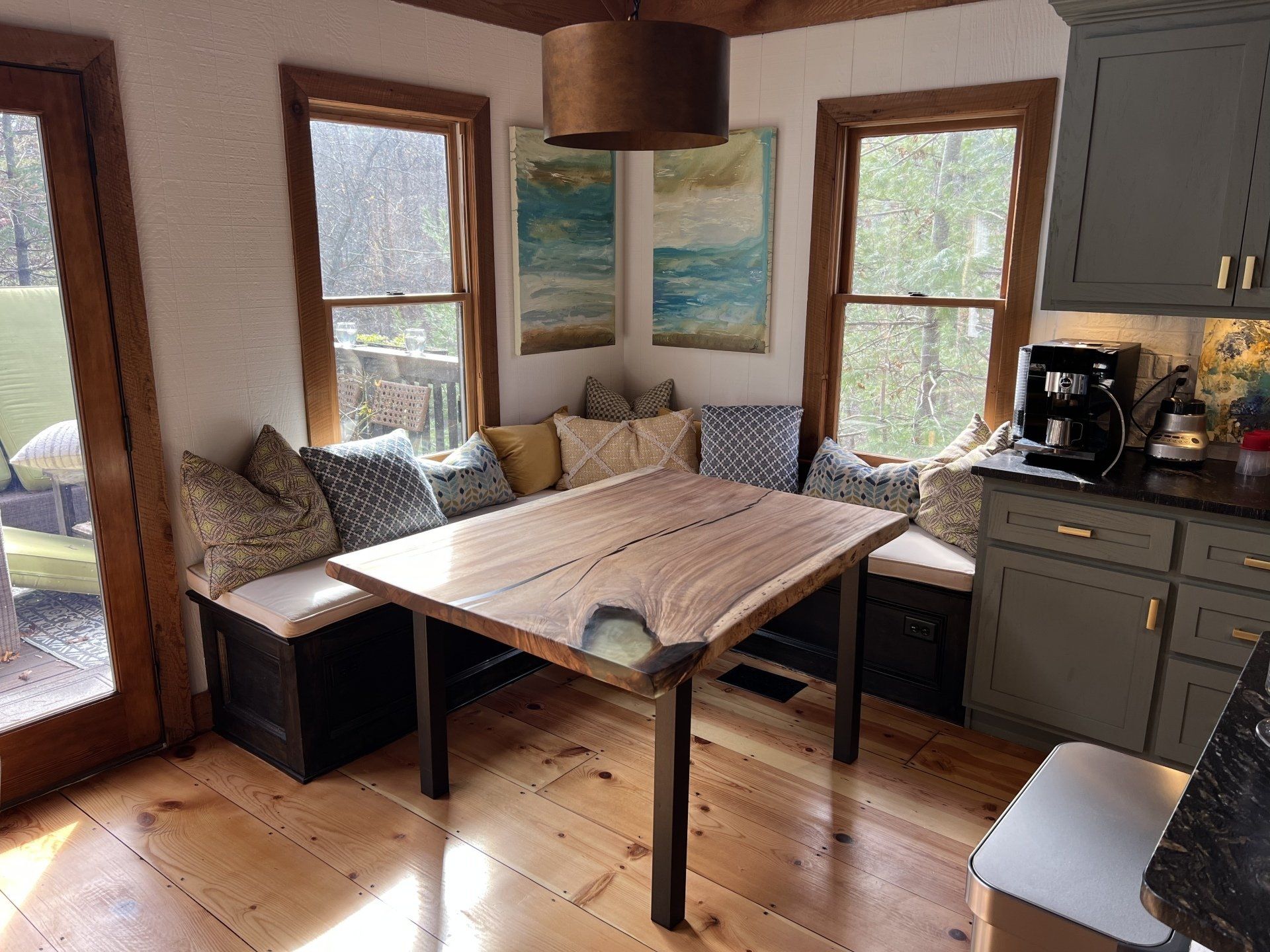 A kitchen with a wooden table and benches in the corner.