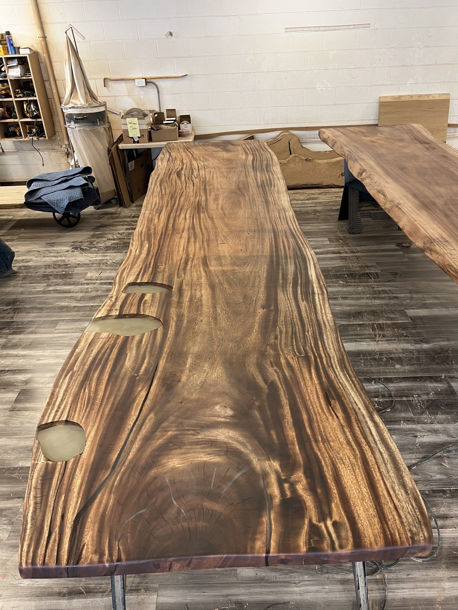 A large piece of wood is sitting on a wooden floor in a room.