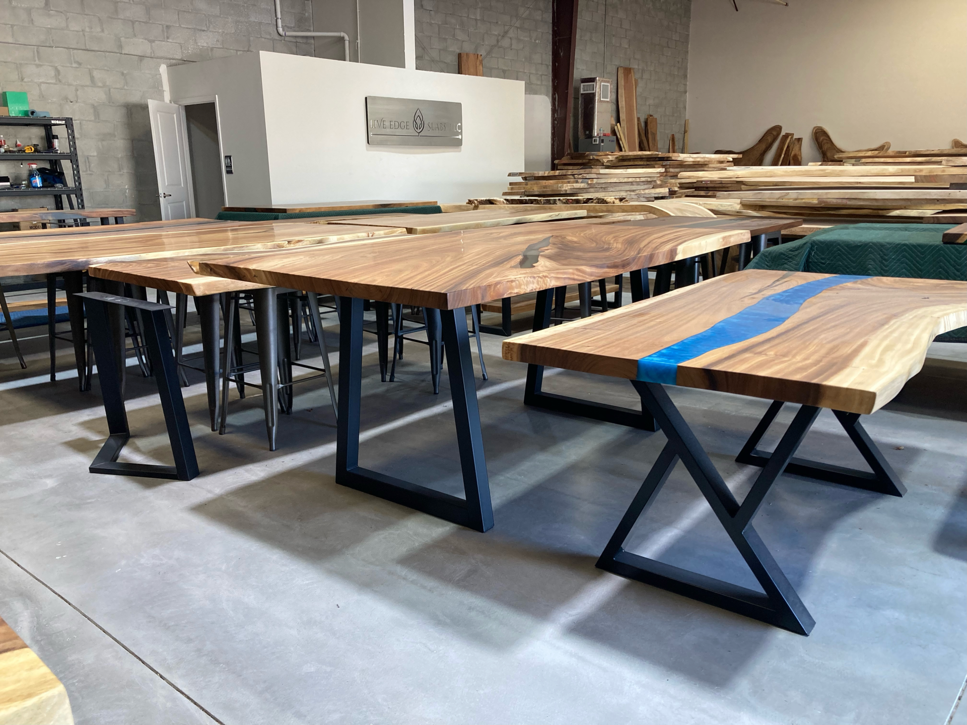 A warehouse filled with wooden tables and stools