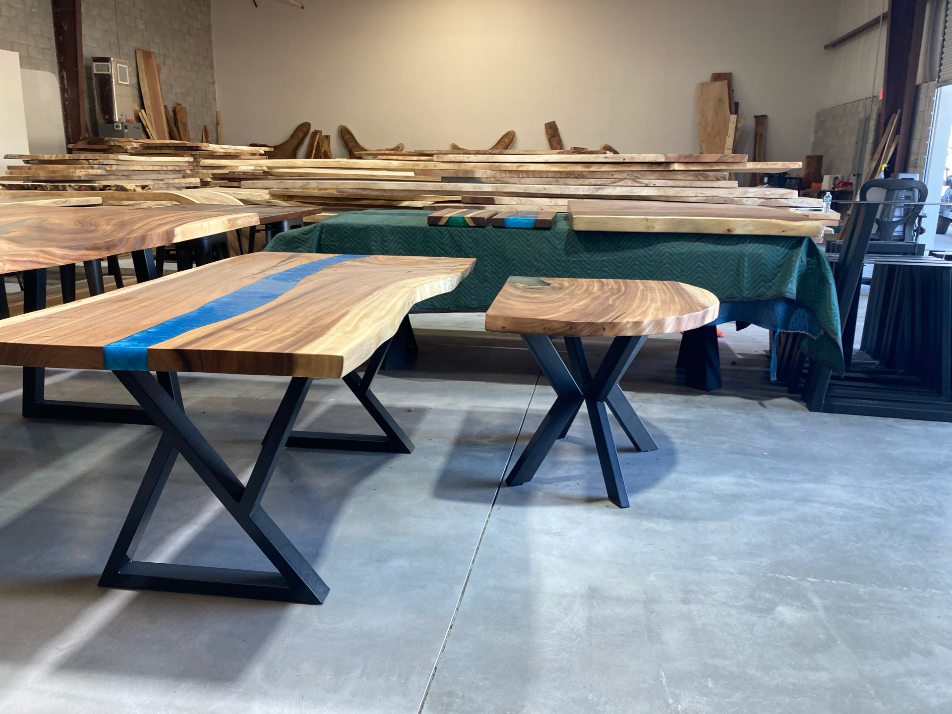 A warehouse filled with wooden tables and stools