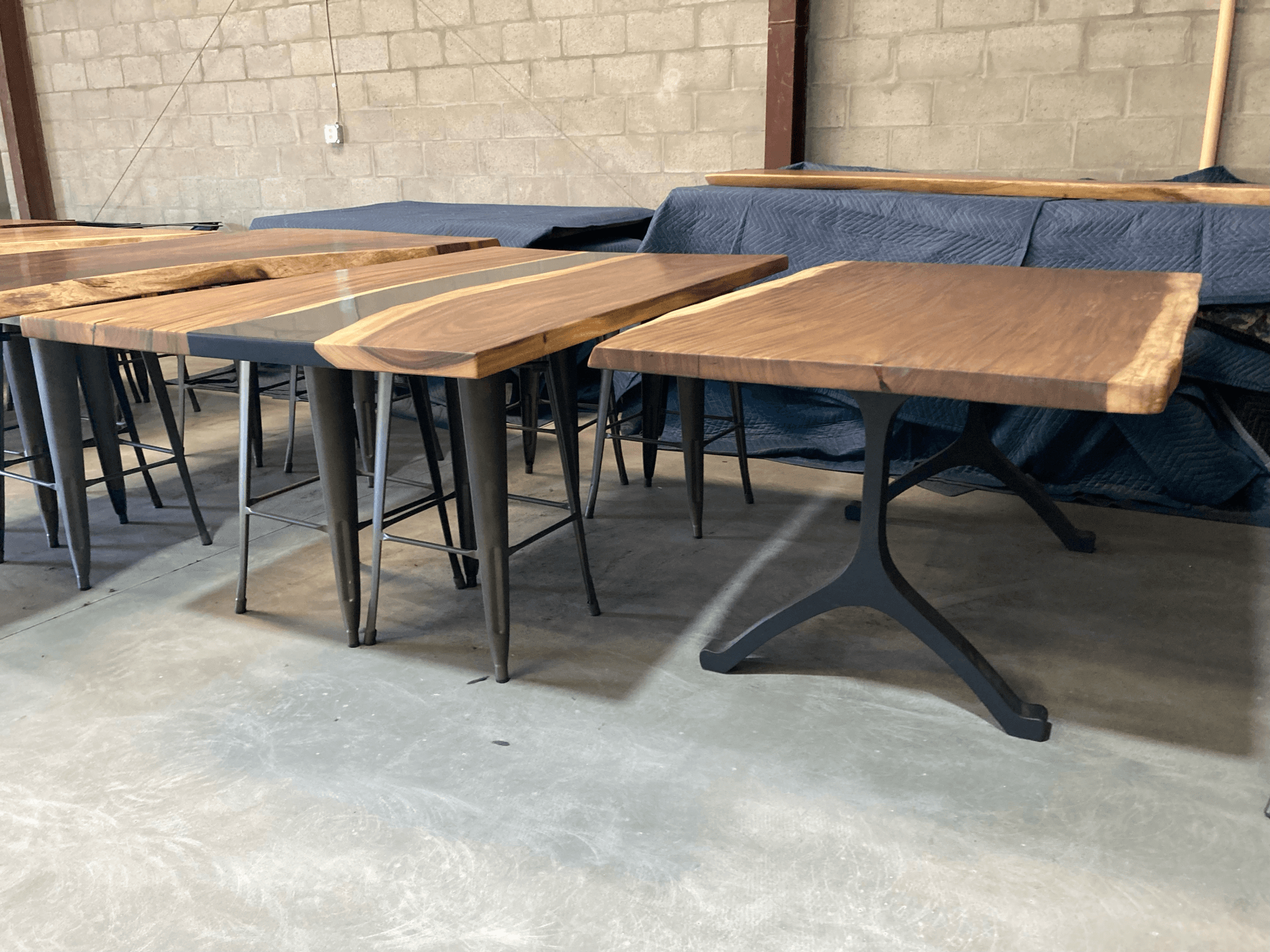 A warehouse filled with wooden tables and stools.